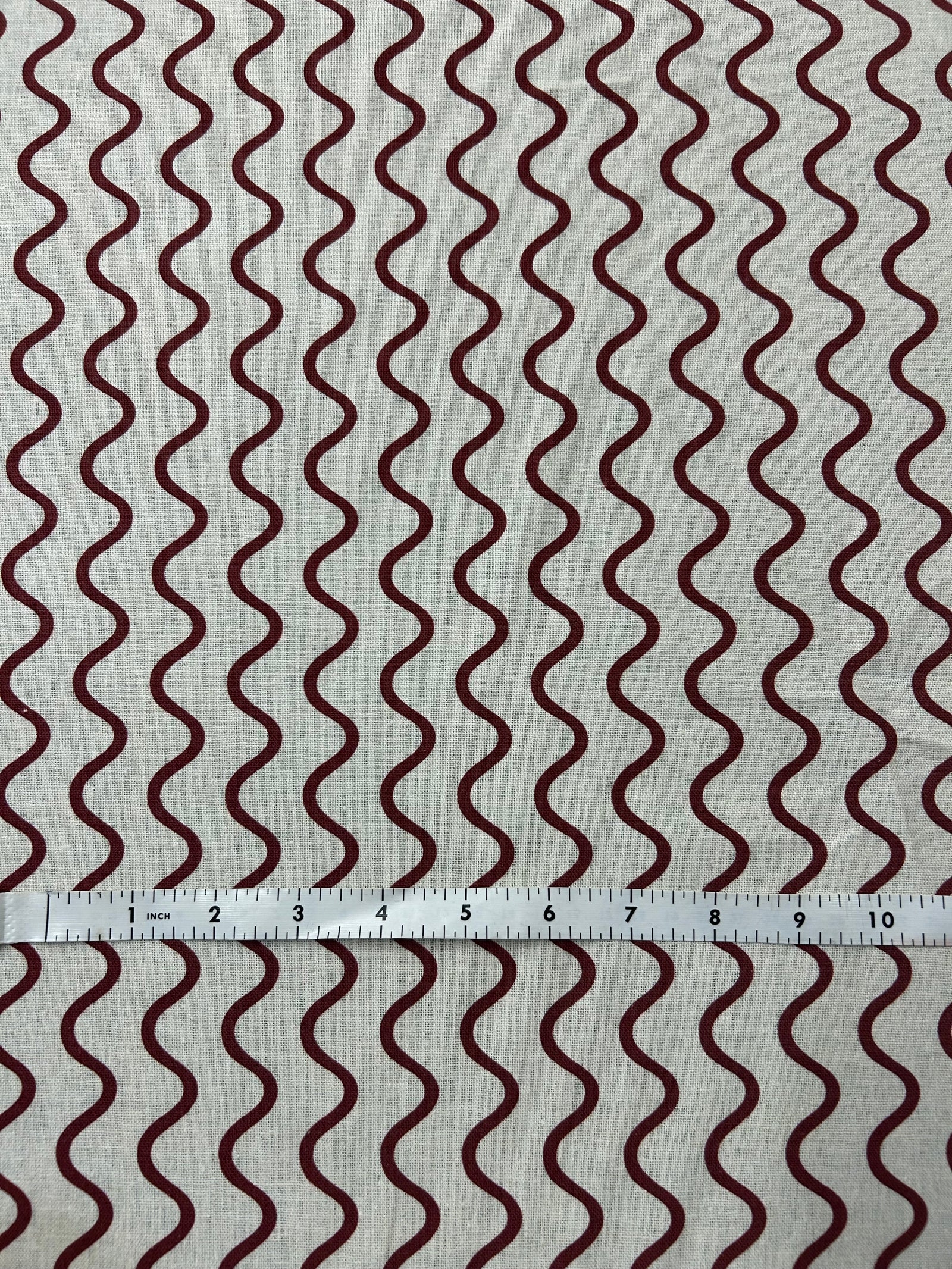 Wavy red stripe pattern on a beige background.