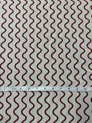 Wavy red stripe pattern on a beige background. and a ruler for scale.