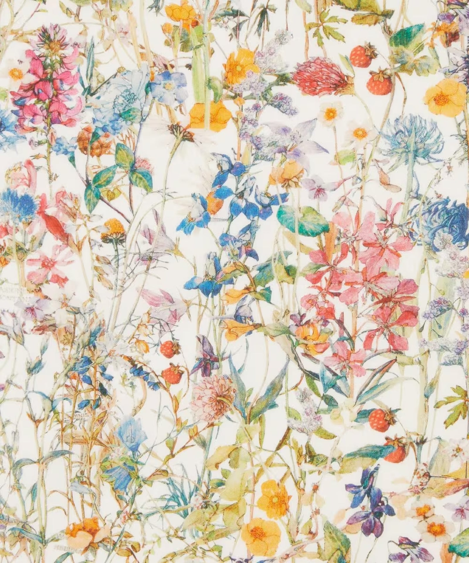 Close up of a soft print of wild flowers of reds, pinks, blues, and yellows with light green foliage on a green background.