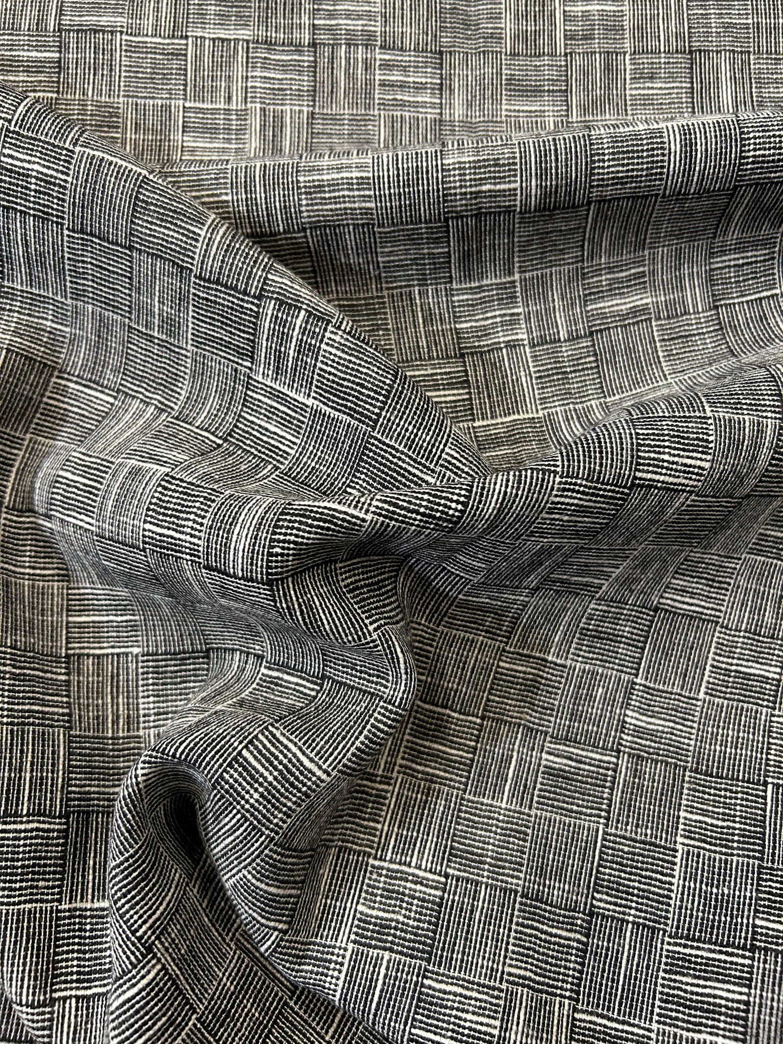 cotton wool blend in a black and white check stripe with a measuring tape on top of the fabric.