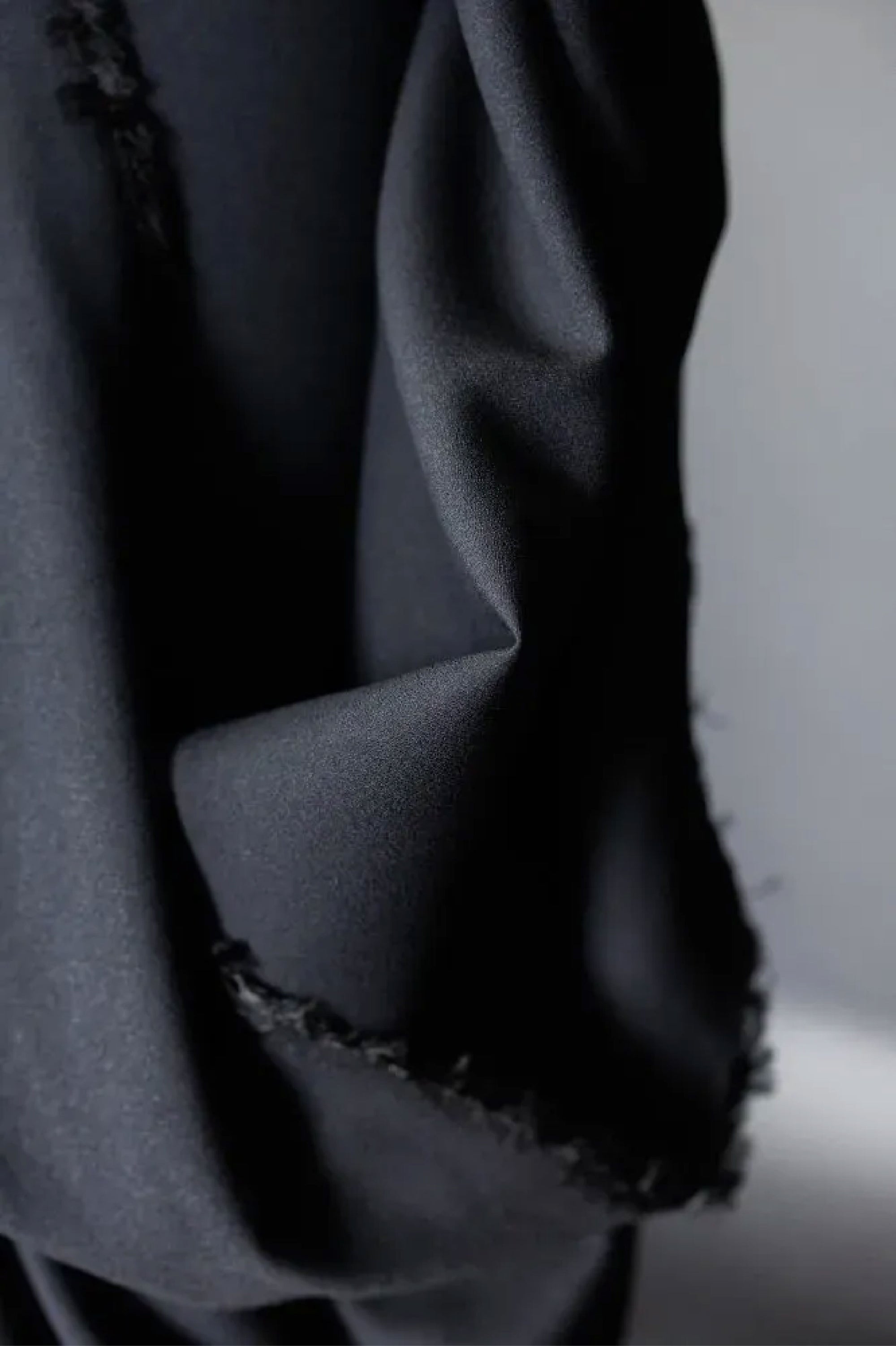 A close up of a mid weight Jet Black wool/viscose blend with a beautiful crepe texture