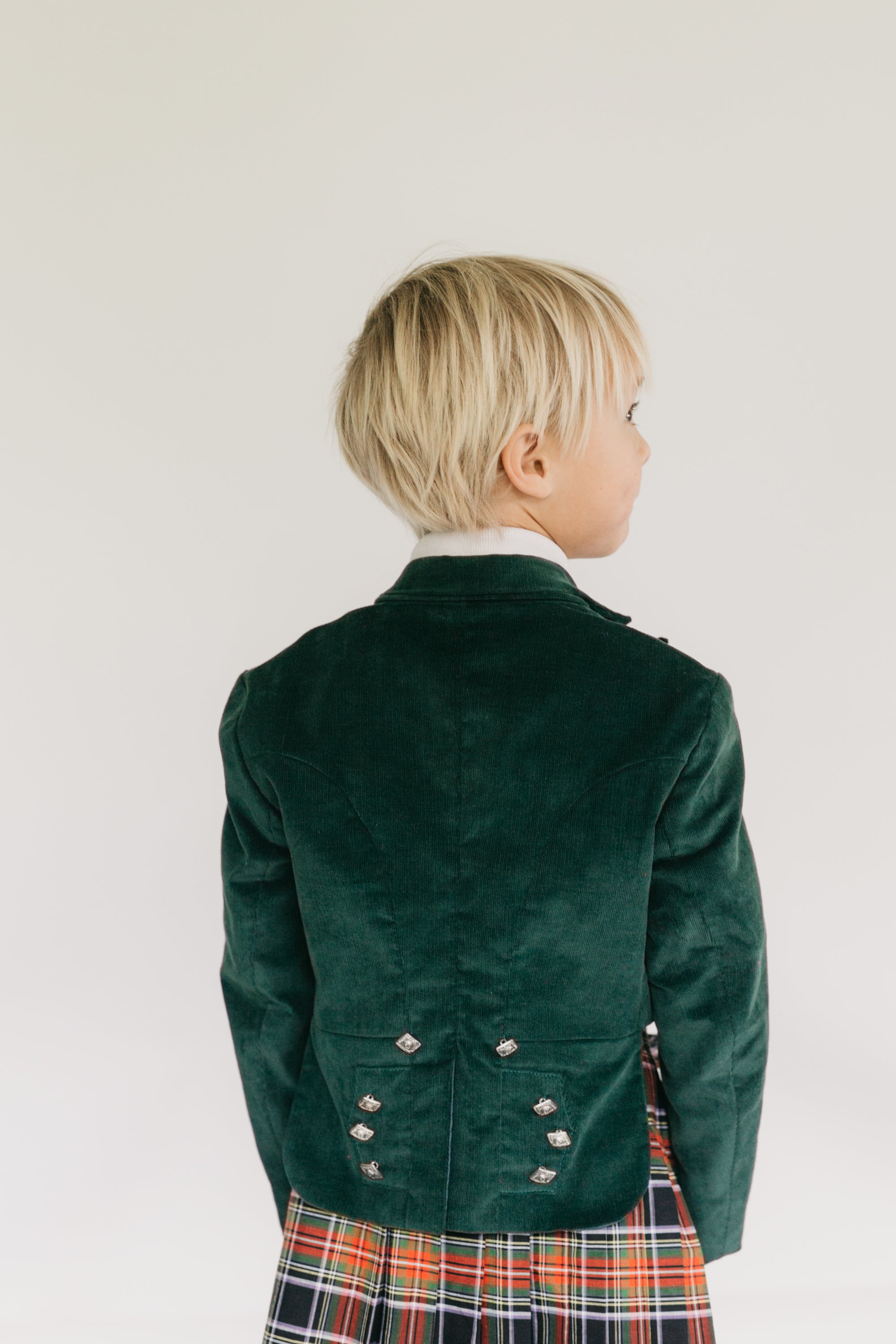 Photo of young boy wearing full Kilt ensemble.  photo shows front and back view of outfit.