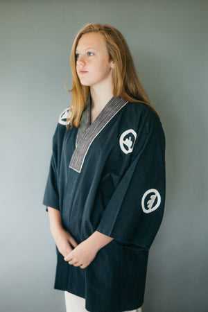 Young woman standing with hands in front of her wearing traditional Hapi Jacket.. 