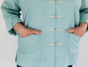 Close up of hands in the pockets of the Chinese pajama Jacket in light blue