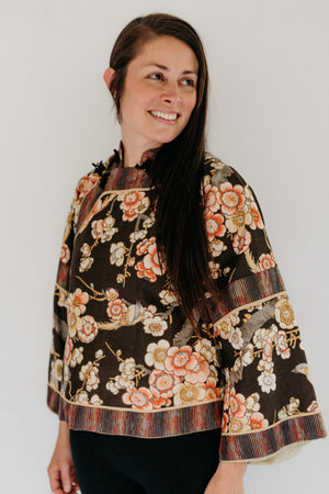 Woman in Floral 114 Chinese Jacket View A.  Standing in front of a white backdrop looking over her left shoulder.