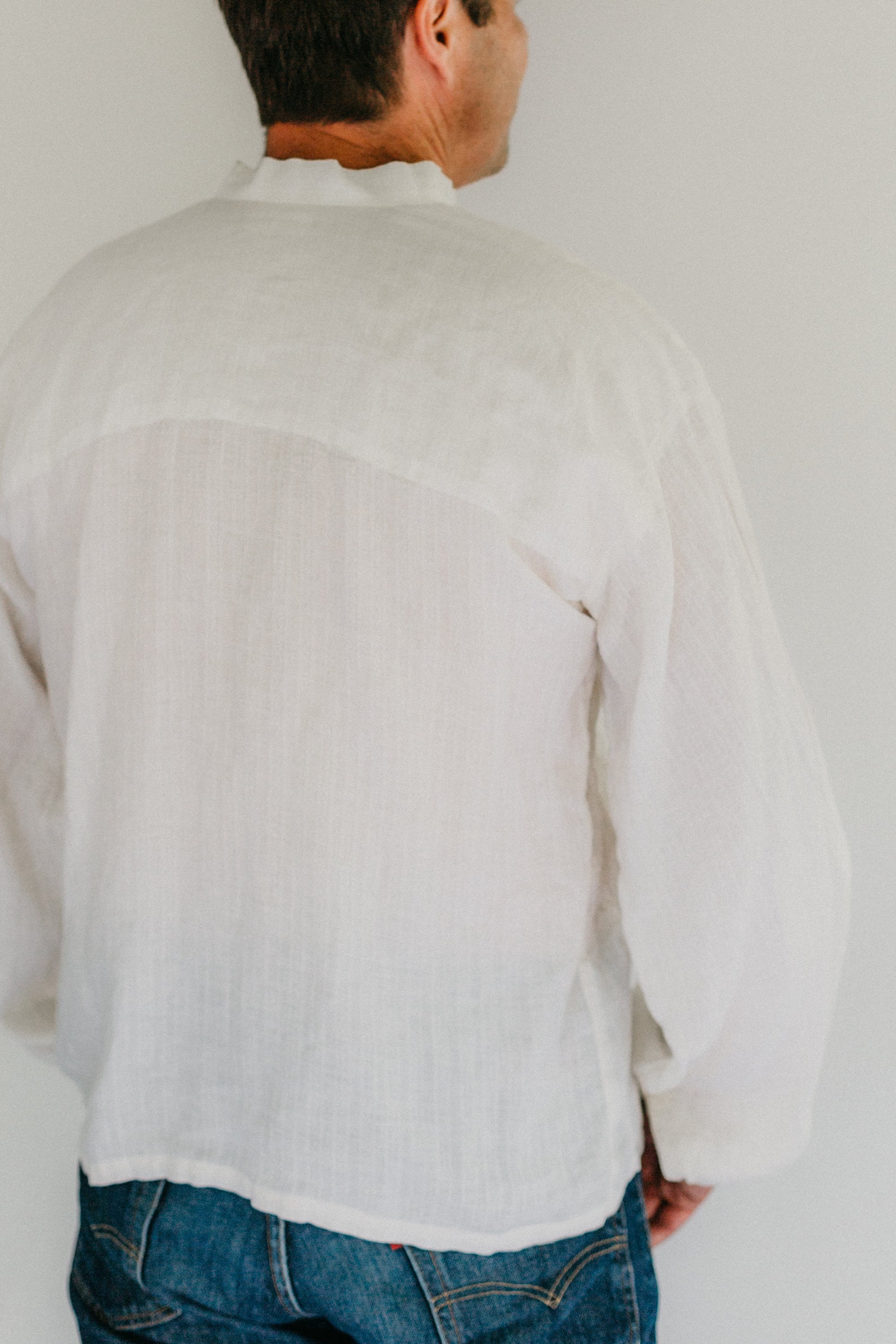 Back view of man wearing view B made in plain white cotton.  View A and C have the same back view.  View B has similar lines except for the gathered sleeves at cuffs