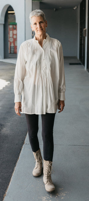 Woman wearing white Croatian Shirt strolls down a sidewalk