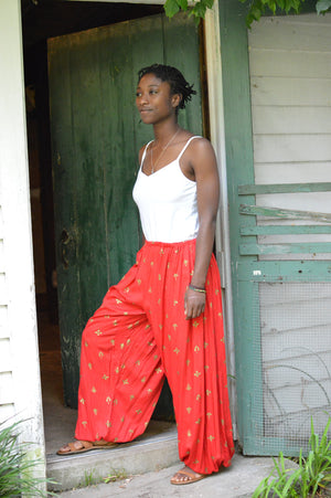 Young African American woman standing in a doorway wearing red 119 Sarouelle pants view A (Turkish Pants)
