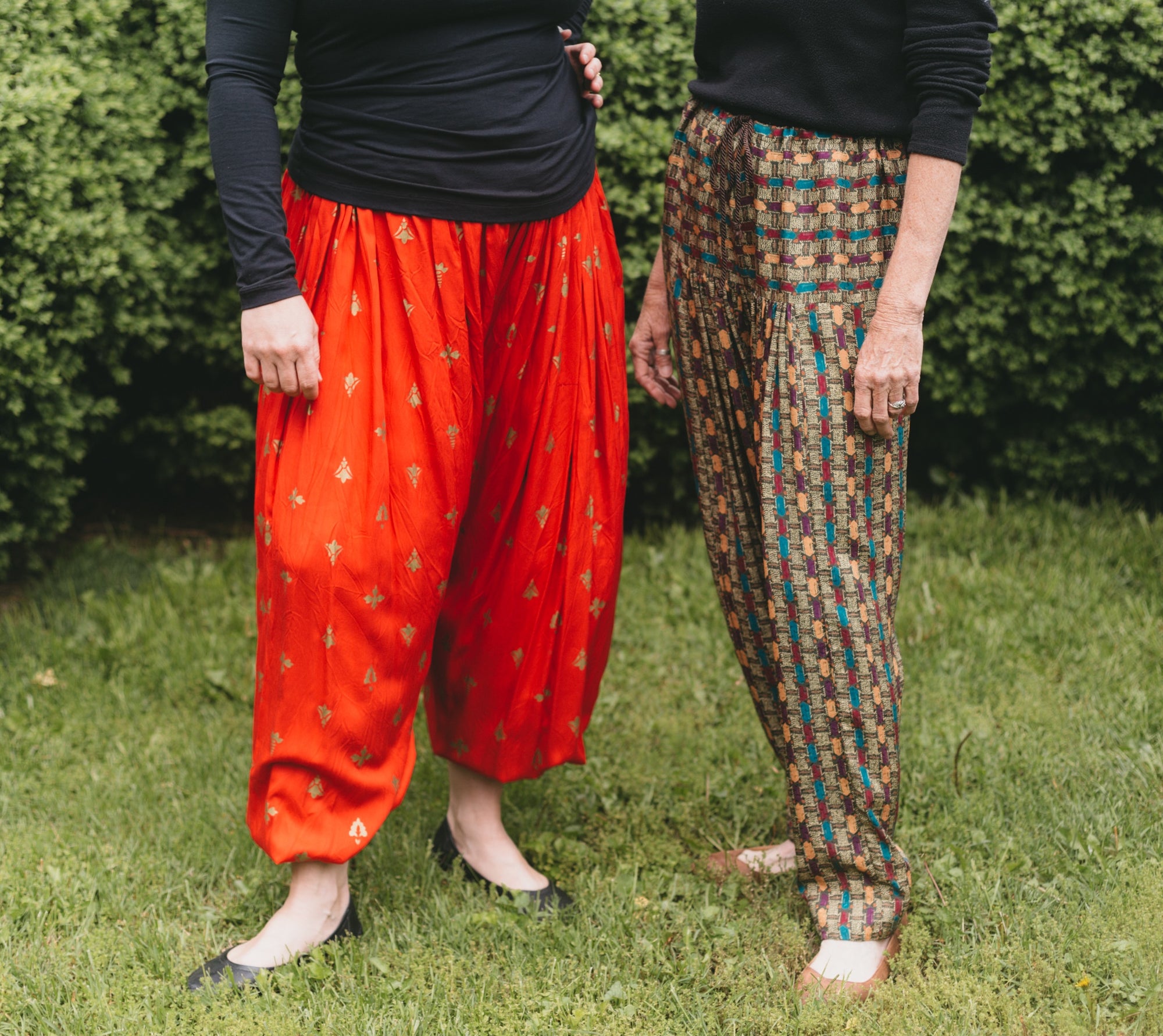Two women standing side by. Photo from waist down.  Woman on left is wearing 119 Sarouelles (View A Turkish Pants).  Woman on right is wearing view C (Indian pants).