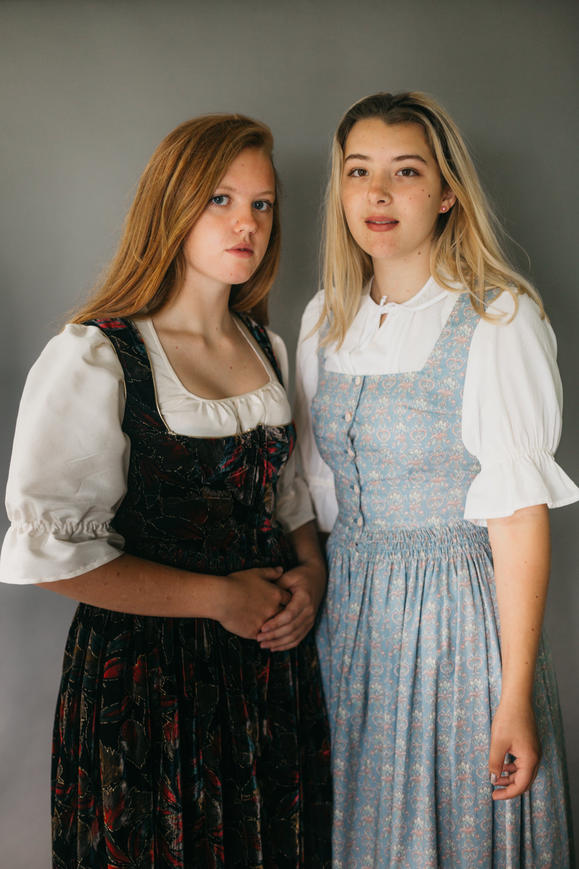 Two young women wearing 123 Austrian Dirndl.  Model on left is wearing view B. Model on right is in View A