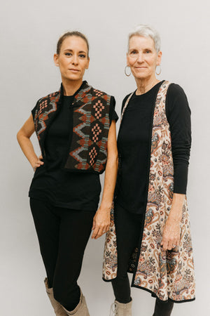 Photo of two women standing side by side in two Views of Greek Vests.  Woman on left is wearing Short Greek Vest and woman on right wears Long Greek Vest.