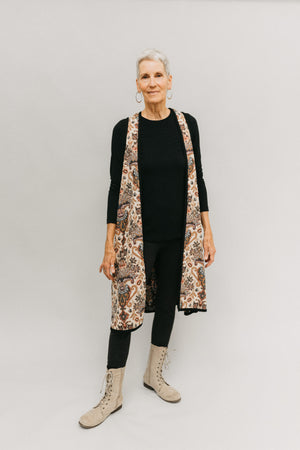 Front view Long Greek vest.  Woman is wearing vest open in front and stands in front of a white backdrop.