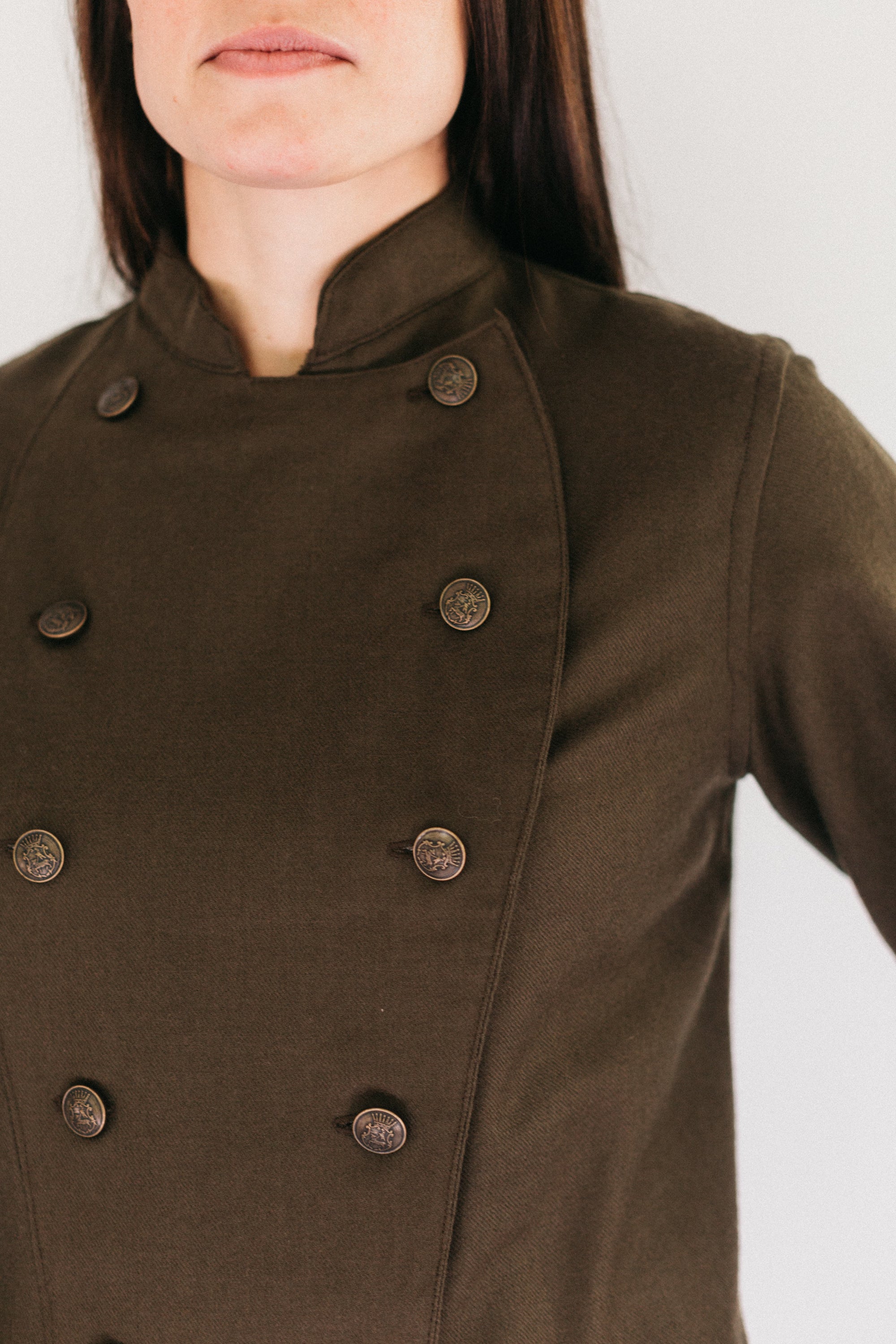 Close up of woman's brown chef's jacket.