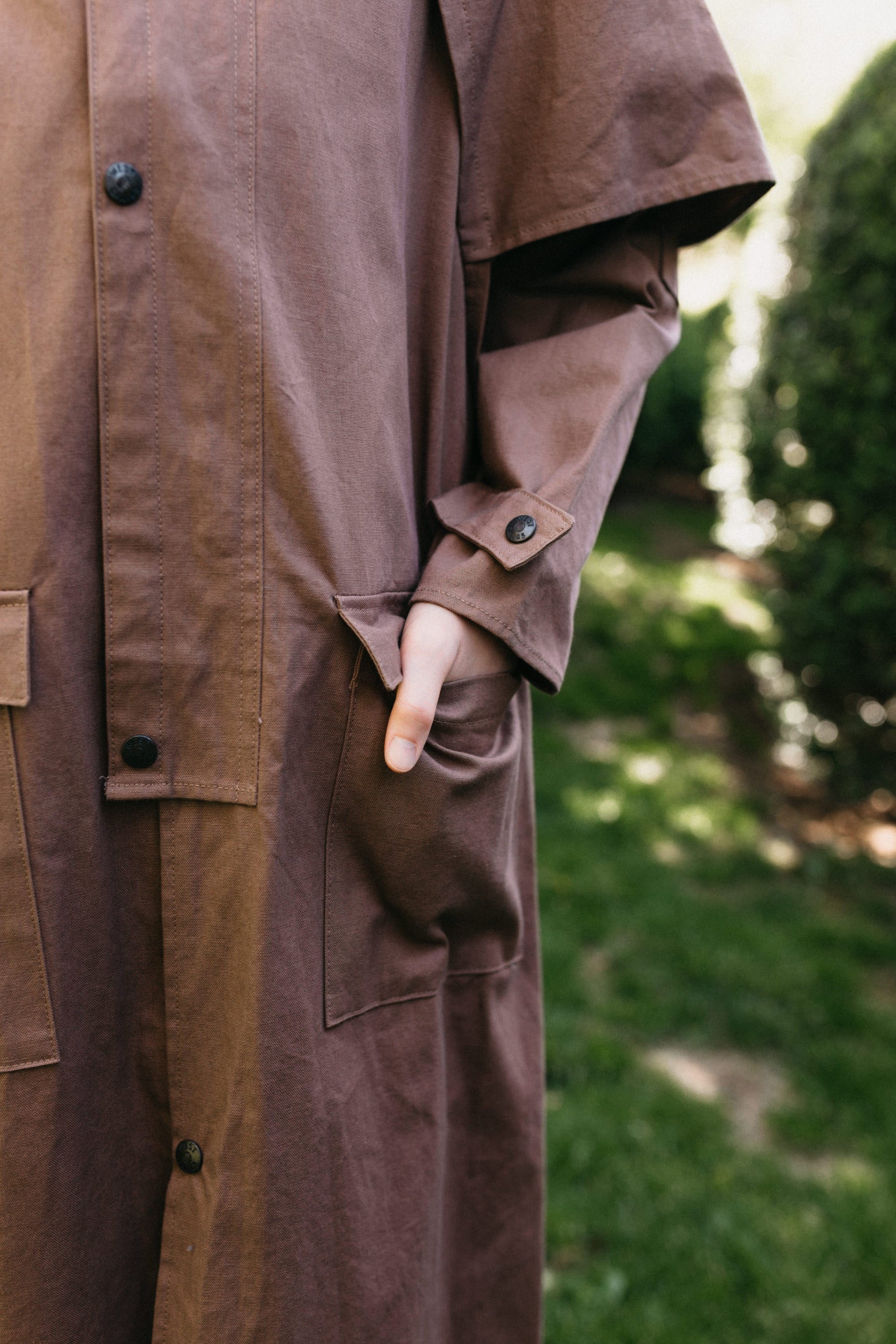 Close up of hand in pocket of brown Drover's Coat.