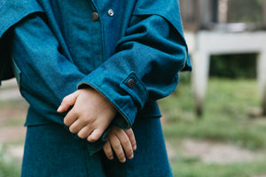 Young girl wearing a blue Australian Drovers Coat.  Close up view of sleeves