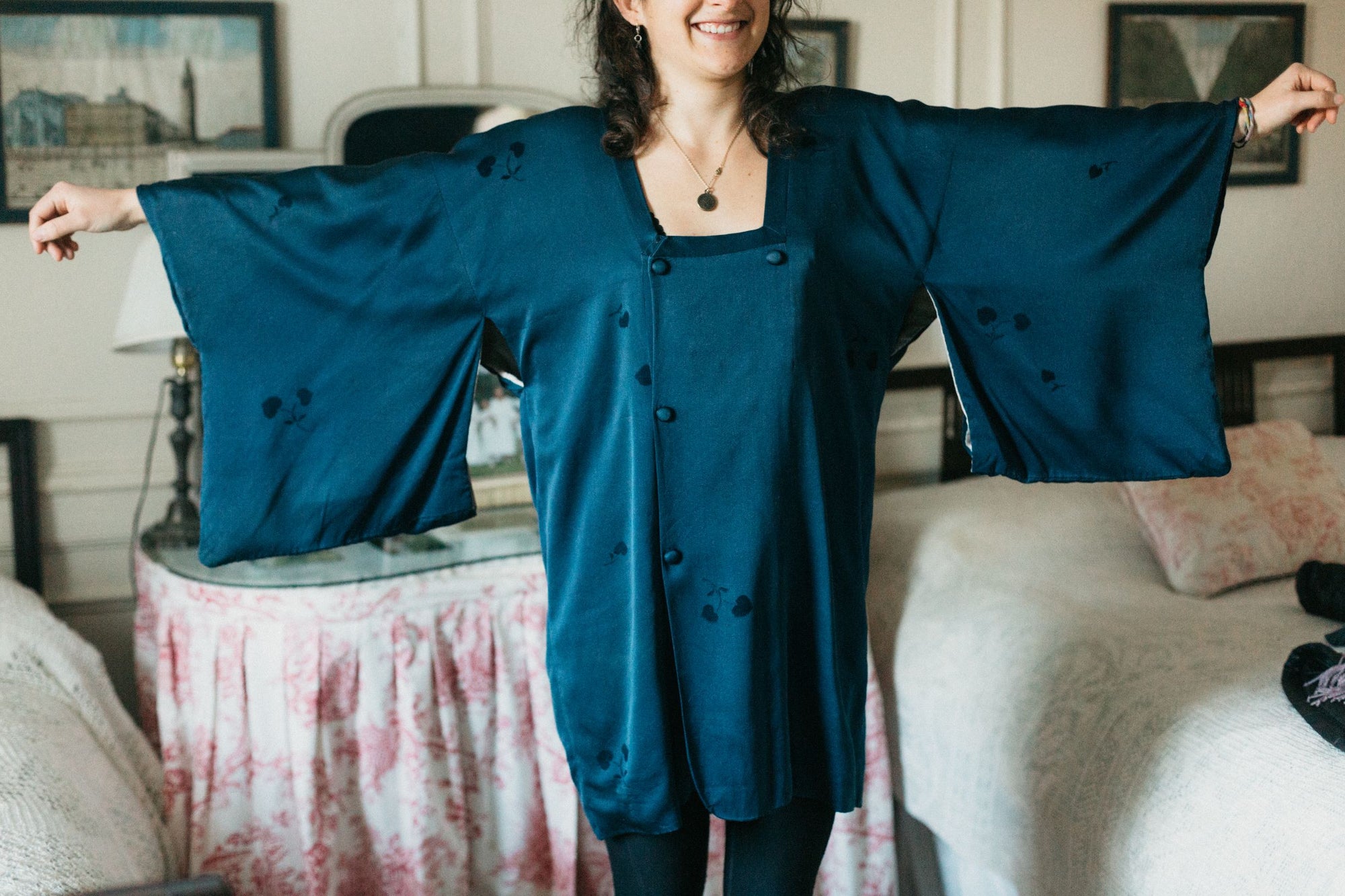 Photo of woman wearing Michiyuki.  She is standing facing camera with arms extended and raised to show full sleeves of the jacket.