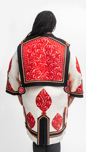 Back view of the szur with decorative red cut felt work over black and white felt coat.