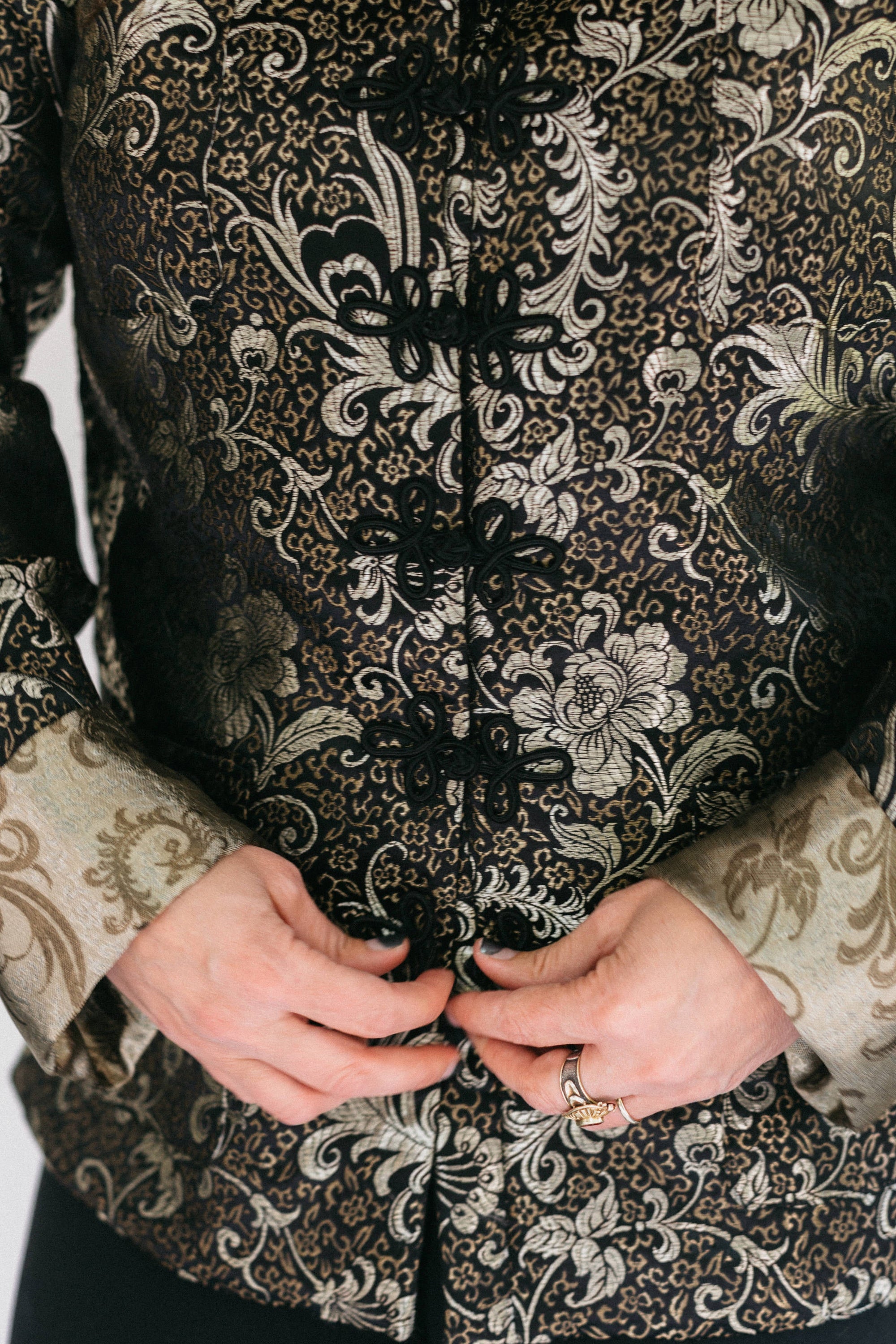 Close up of woman butting loop frog closures on the Chinese Pajama jacket.