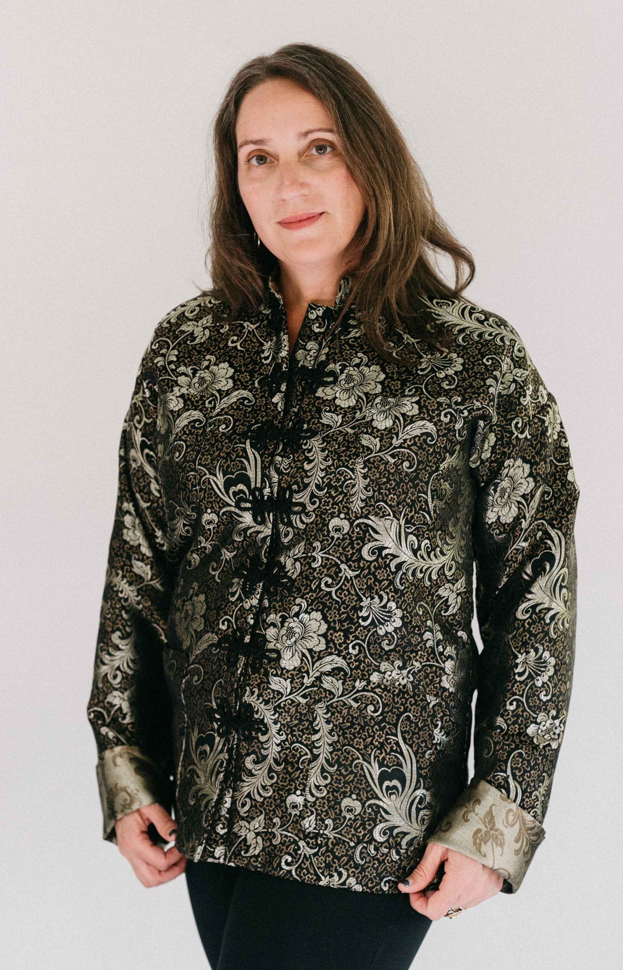 Brunette white woman standing in in front of a white studio backdrop wearing #145 Chinese Pajama Jacket