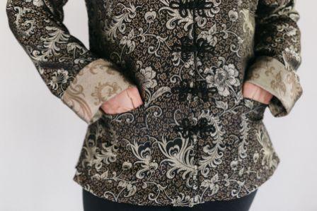 close up of hands in pockets of the Chinese pajama jacket with loop frog closures.
