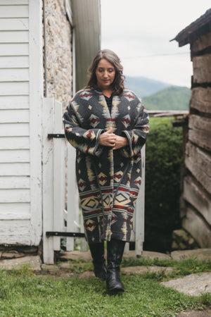 woman walking outside wearing a Hungarian Szur made of heavy wool. Szur is contemporary view B.