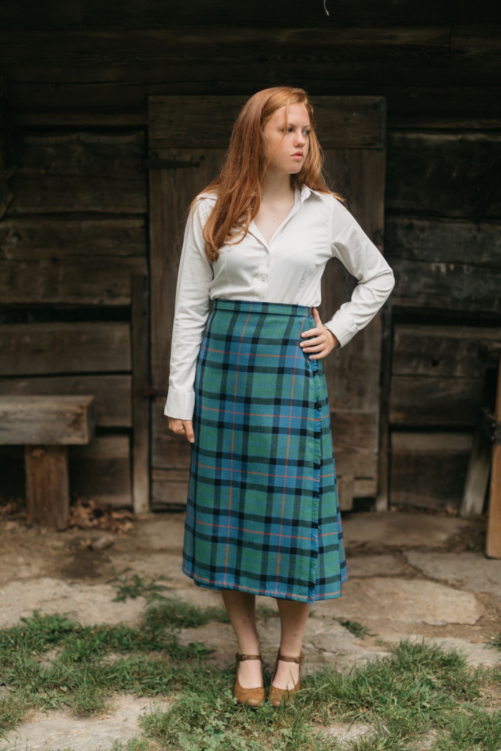 Photo of a young woman standing outdoors wearing the kilt skirt.