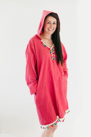 brunette white woman smiling, standing in front of a white studio backdrop, wearing the #157 Moroccan Djellaba pullover with hands in pockets.