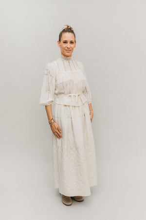 Blonde woman standing in front of white studio backdrop wearing 206 Gibson Girl Blouse with matching skirt.