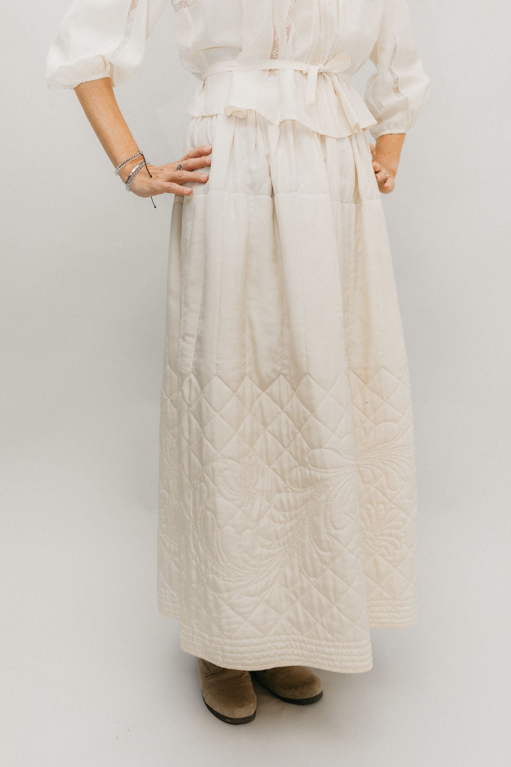 waist down view of woman standing with hands on her hips in front of a white studio backdrop, wearing 206 Quilted Prairie Skirt.