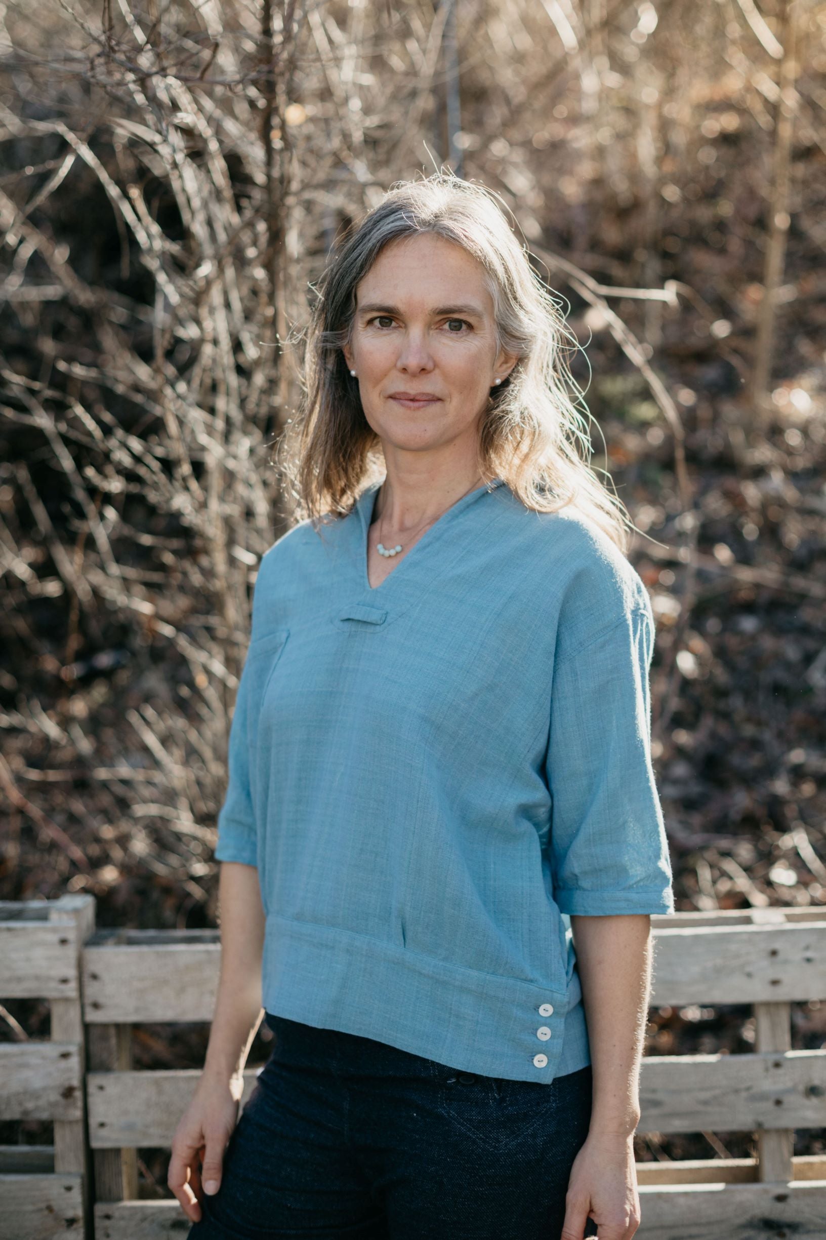 A white woman standing outside wearing the 211 Two Middies v-neck.