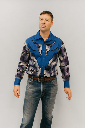 Man standing in front of a white studio backdrop, wearing 212 Five Frontier Shirt with decorative bull's head yoke.