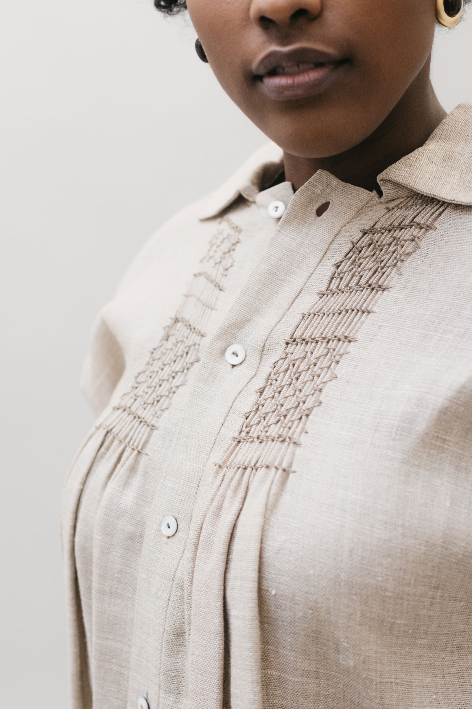 Close up of African American woman bust of 221 English Smock Frock, button opening and embroidery. 