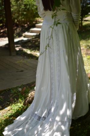 Close up back view of woman wearing 227 Edwardian Bridal Gown and Dress trail of the full sweep of skirt.