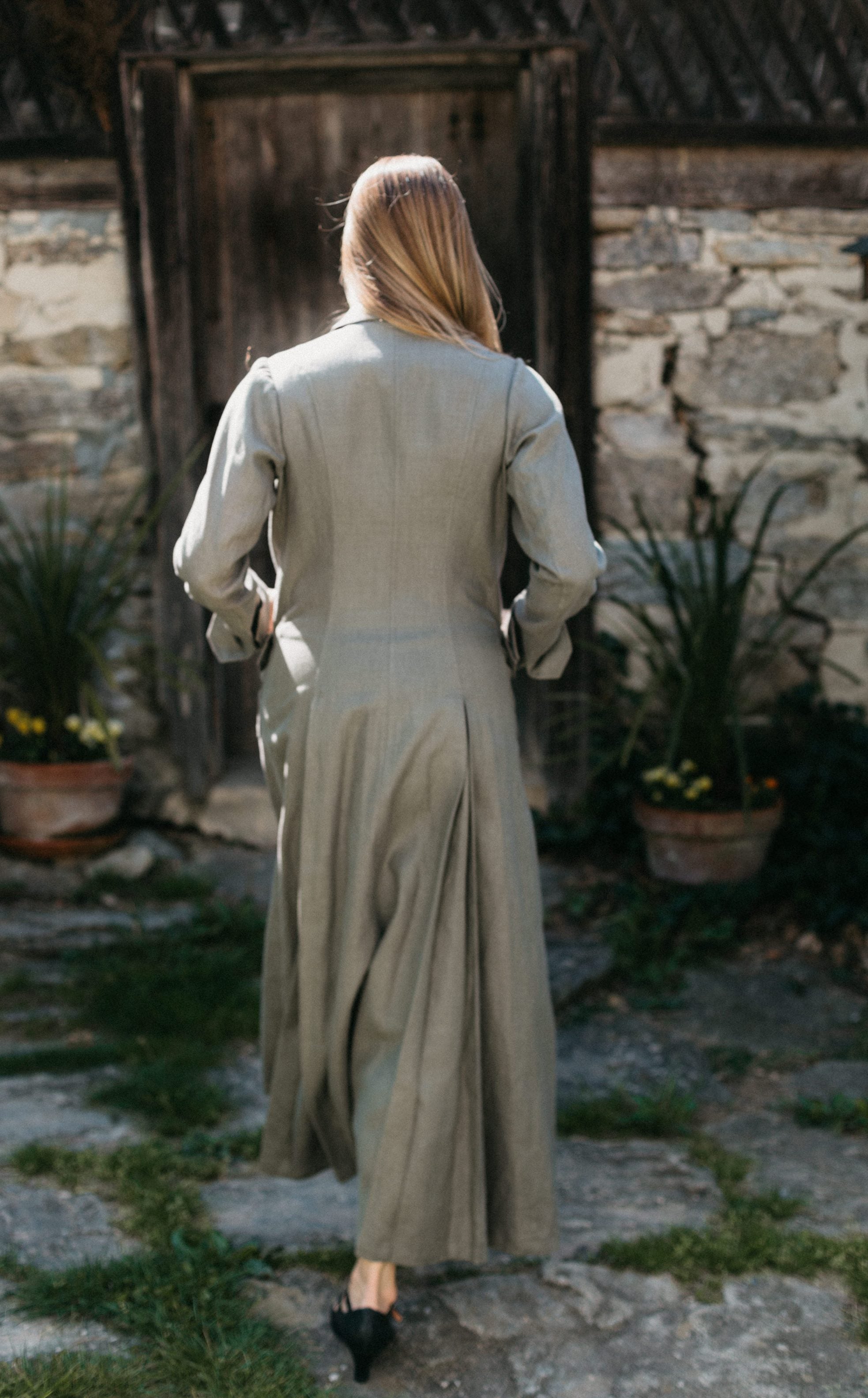 Back view of woman walking with hand in pockets wearing 230 Model T Duster