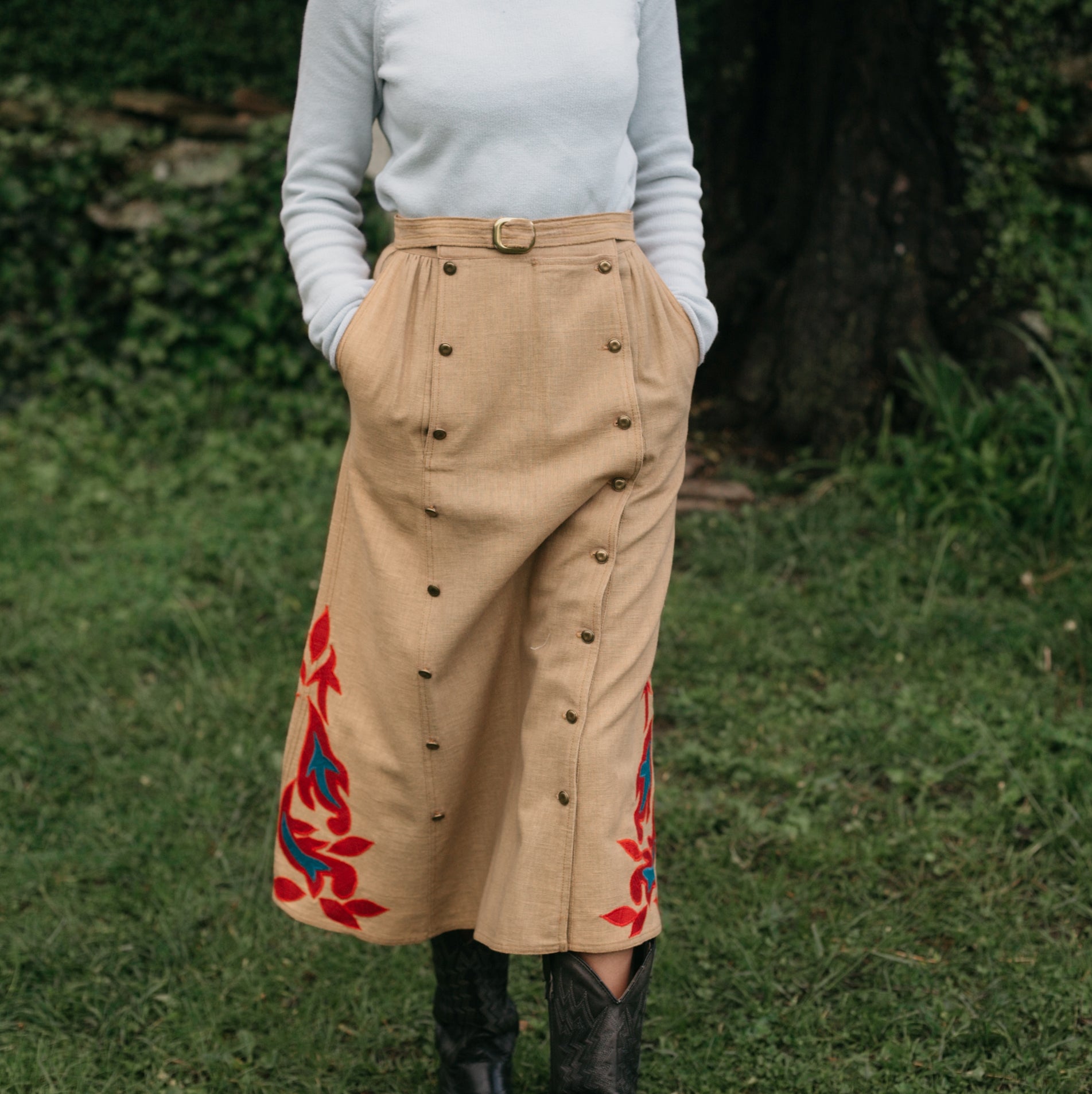 Close up of woman walking surrounded by greenery 231 Big Sky Riding Skirt buttoned to the left for a skirt effect 