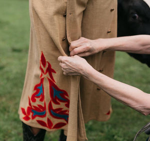 Close up view of a woman buttoning the buttons of another woman wearing the 231 Big Sky Riding Skirt.