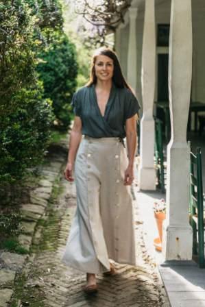 Photo of model wearing a short sleeve version of Thai Blouse.  Model walks outdoors and wears top with 231 Big Sky Riding Skirt.