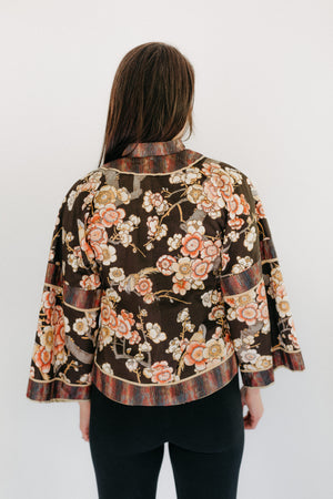 Back view of View A.  Woman is standing with hands by her side in front of a white backdrop.