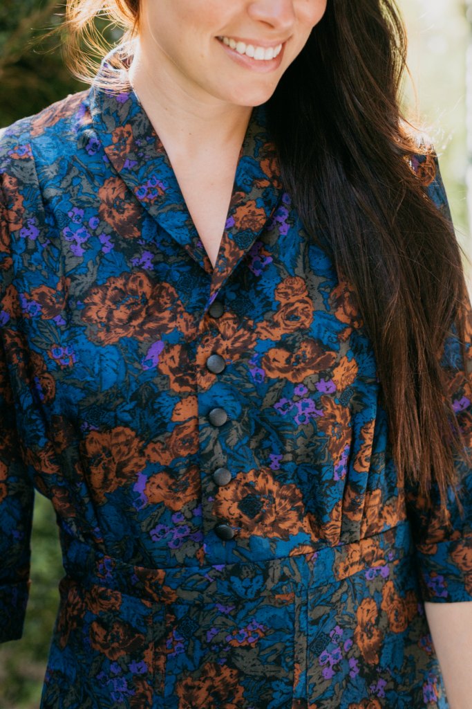 Close up of woman wearing the Lindy Shirtdress buttoned looking down smiling.