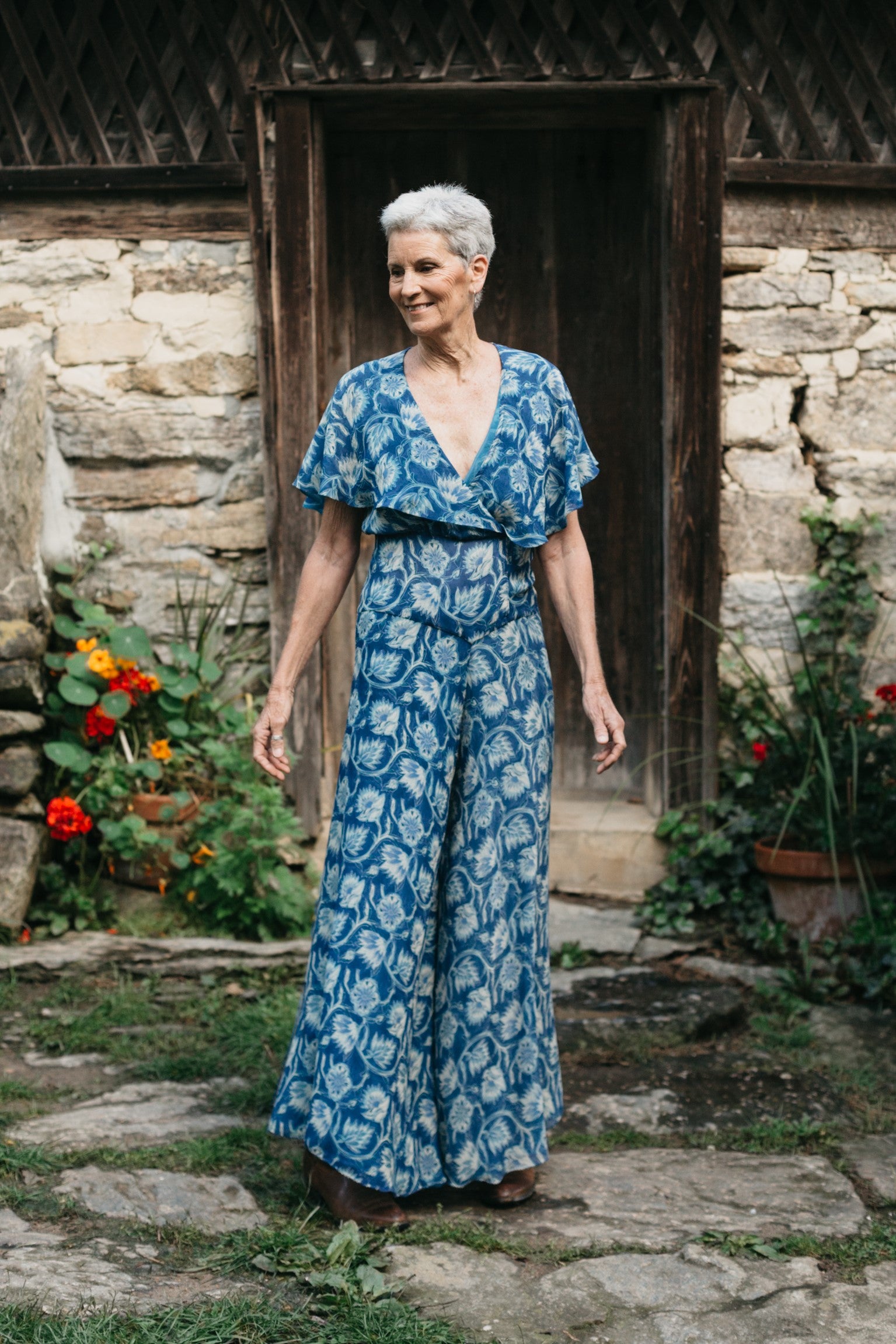 Woman wearing ankle length 252 Beach Pajamas.  Standing outdoors in front of a stone building.