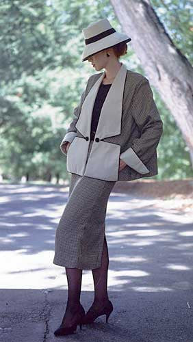 Woman standing surrounded by greenery wearing the Swing Suit with a hat