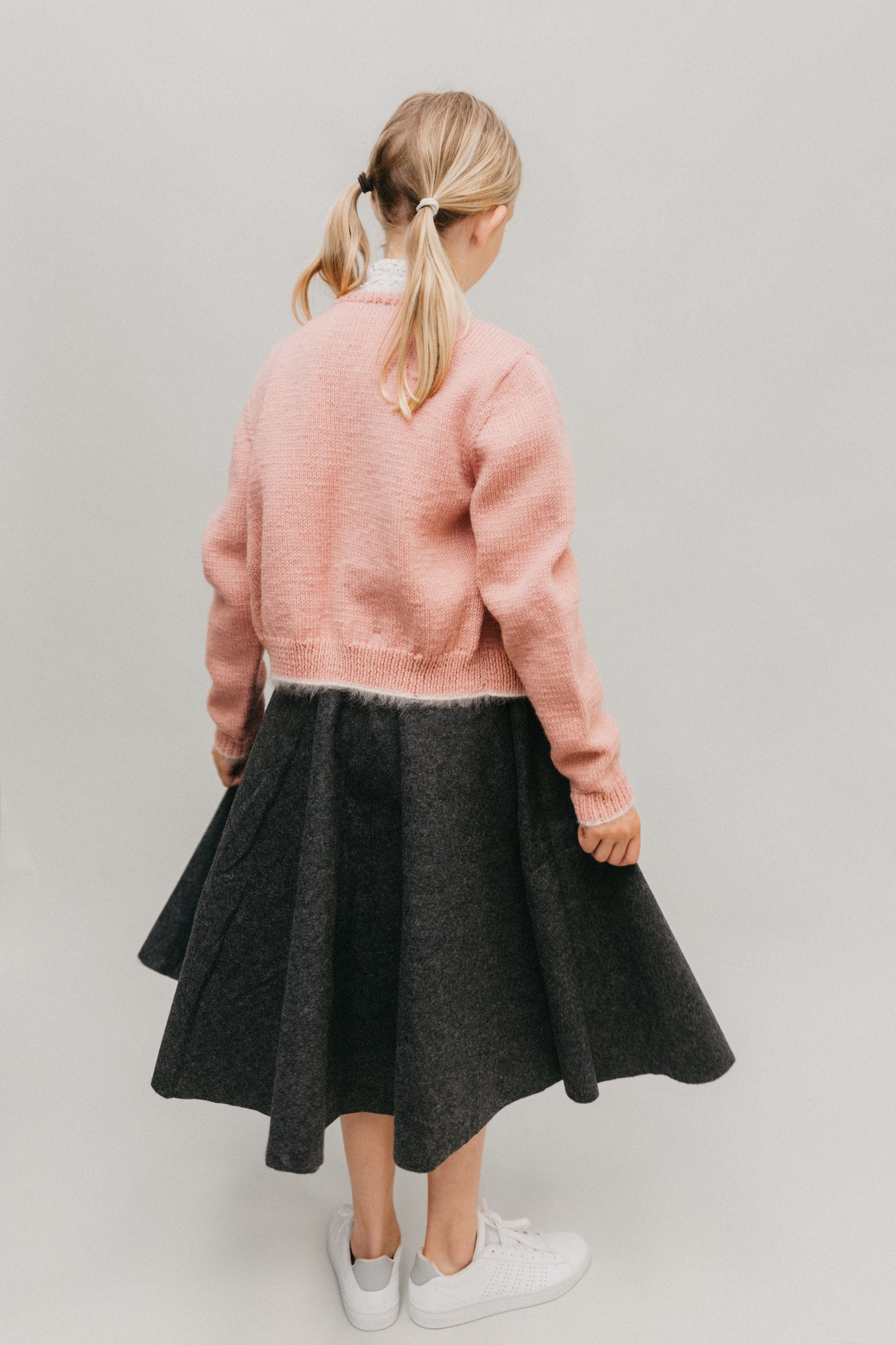 Back view of young blonde girl wearing the At The Hop Sweater and skirt