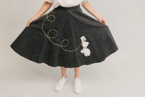 Close up of the At The Hop skirt fanned out with her hands,with poodle design