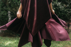 Woman standing surrounded by greenery, Close up of the bottom of the Monte Carlo Dress withe V-Neck Tunic flared.