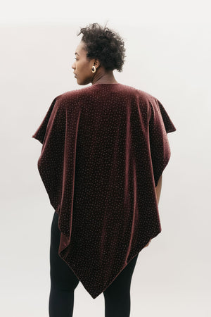 Back view of African American woman with short black hair wearing the Monte Carlo V-Neck Tunic in  maroon in front of a white studio backdrop head turned to the left. 