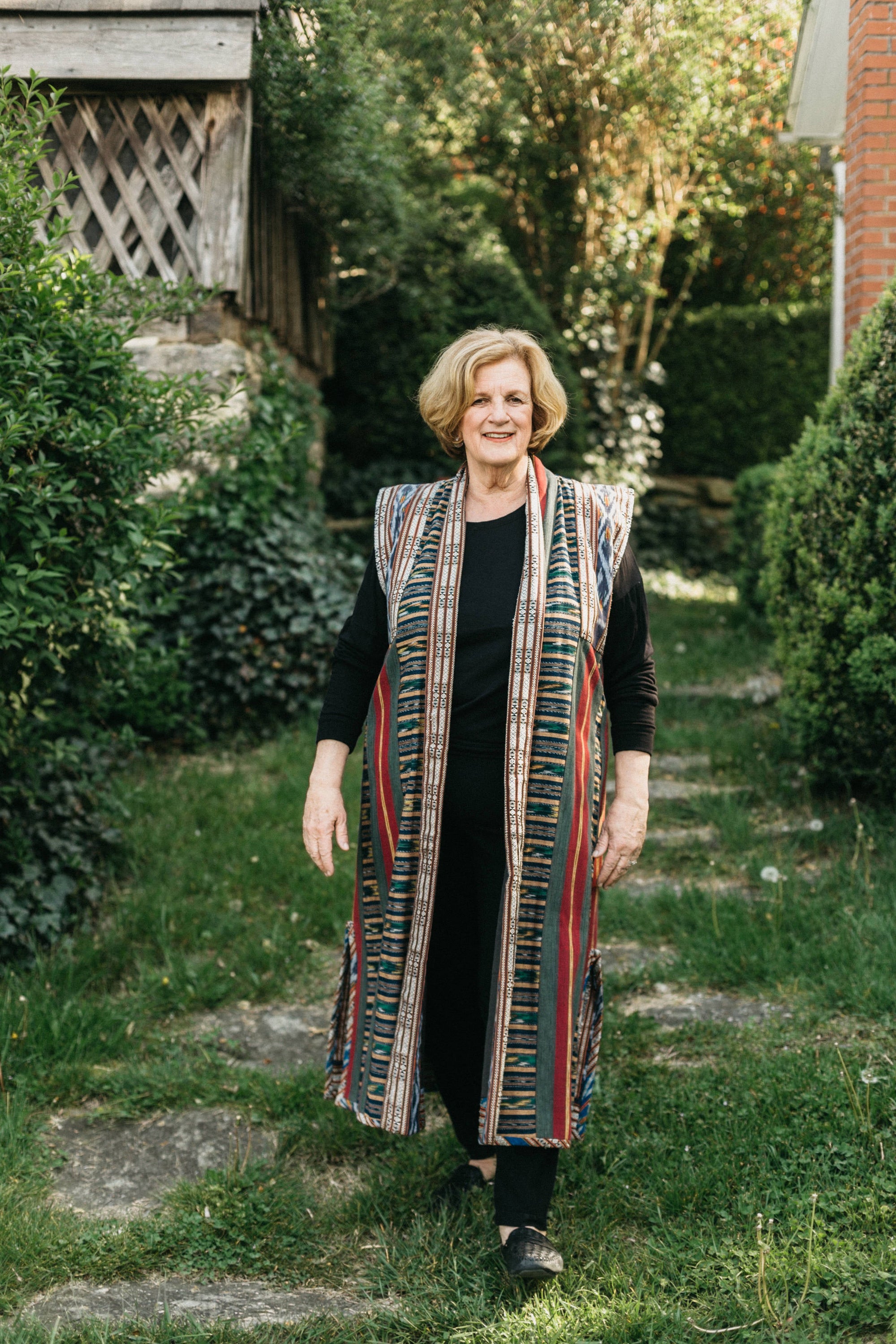 Woman walking outdoors in panel coat.  Coat is made with woven Ikat fabric.