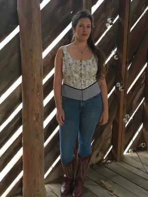Woman standing in barn wearing jeans and boots and  floral patterned Corset top pattern for cottagecore bohemian look sleeveless vest top pattern for women