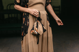Close up from the waist down of the front Promenade Dress with the drawstring bag held in front.