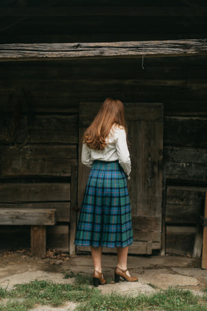 Photo of the back view of the kilt skirt on young woman walking.