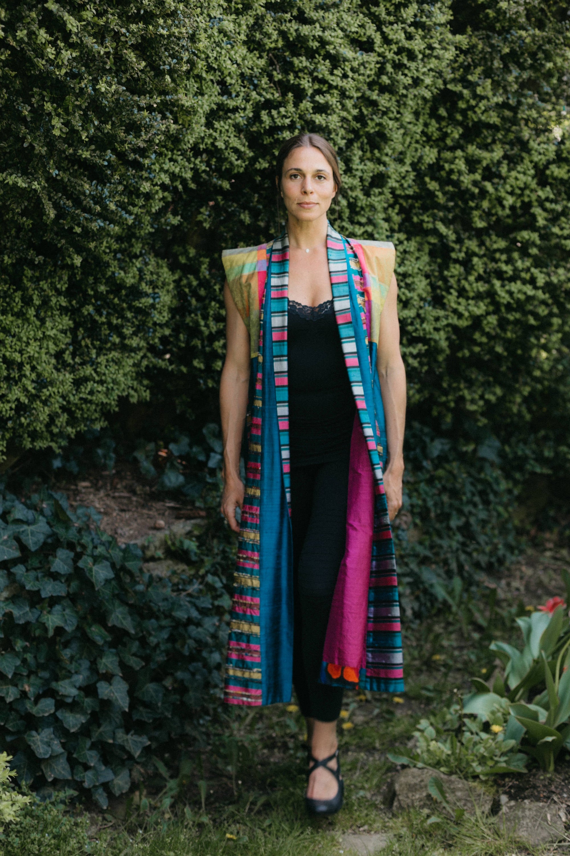 Woman walking outside wearing multi colored Tibetan panel coat